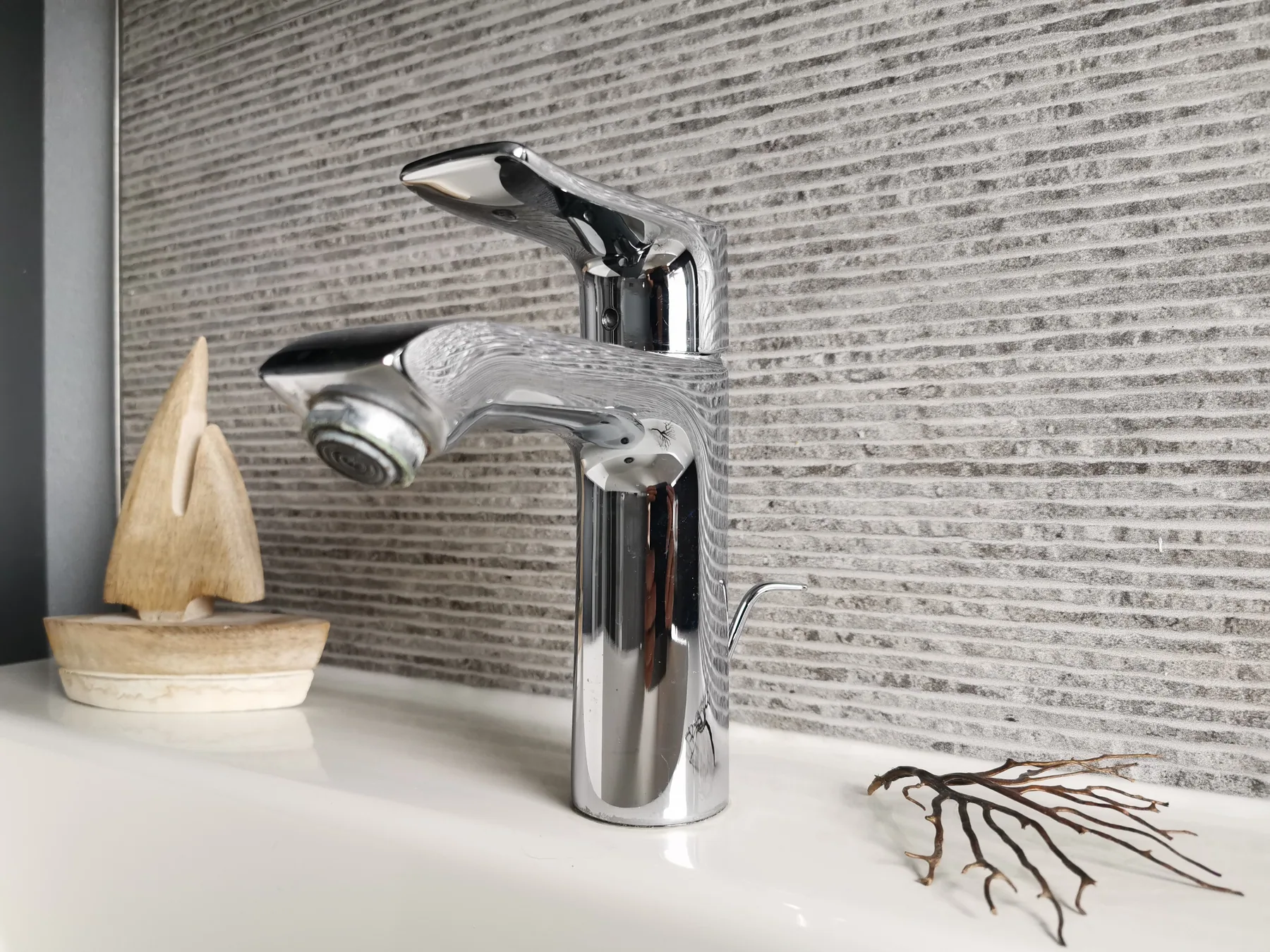 Chromarmatur am Waschbecken mit maritimer Dekoration